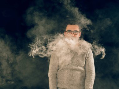 Genç adam elektronik sigara içiyor.