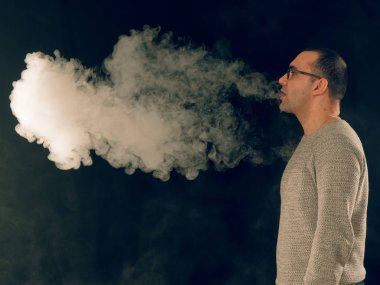 Genç adam elektronik sigara içiyor.