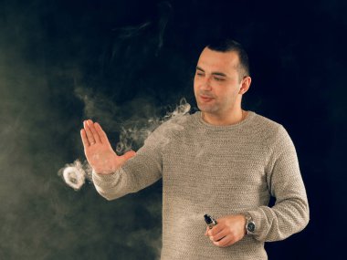 Genç adam elektronik sigara içiyor.