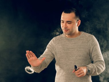 Genç adam elektronik sigara içiyor.