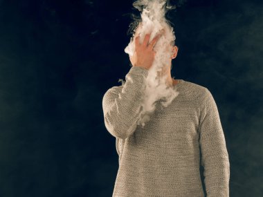 Genç adam elektronik sigara içiyor.