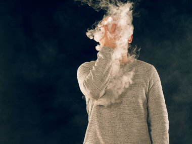 Genç adam elektronik sigara içiyor.