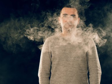 Genç adam elektronik sigara içiyor.