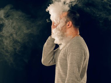 Genç adam elektronik sigara içiyor.