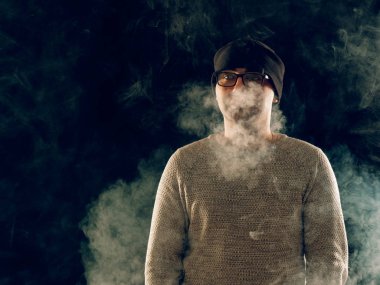 Genç adam elektronik sigara içiyor.