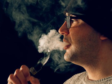 Genç adam elektronik sigara içiyor.