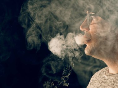 Genç adam elektronik sigara içiyor.