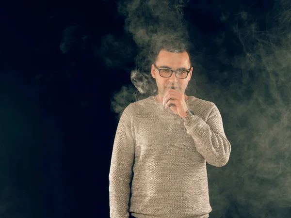 Genç adam elektronik sigara içiyor.