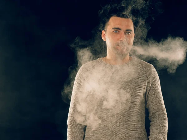 Genç adam elektronik sigara içiyor.