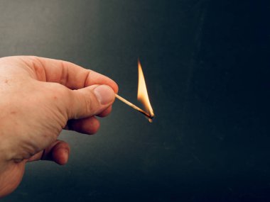 siyah arka plan üzerine elinde yanan kükürt büyükbaş