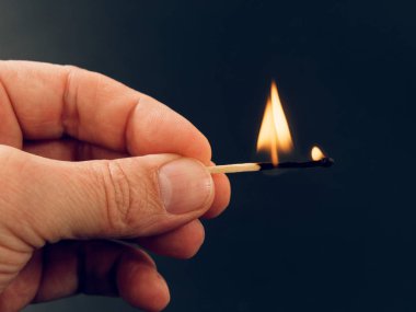 siyah arka plan üzerine elinde yanan kükürt büyükbaş