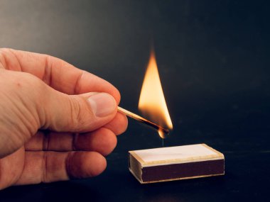 siyah arka plan üzerine elinde yanan kükürt büyükbaş