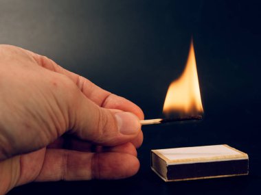 siyah arka plan üzerine elinde yanan kükürt büyükbaş