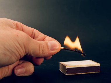 siyah arka plan üzerine elinde yanan kükürt büyükbaş