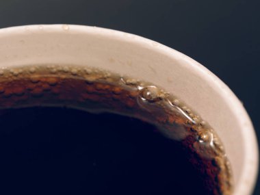 karanlık bir arka plan üzerinde kırmızı kağıt bardak içki