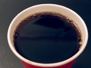 karanlık bir arka plan üzerinde kırmızı kağıt bardak içki