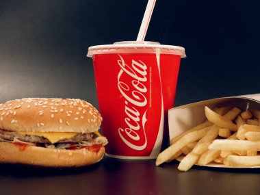 Gomel, Belarus - 5 Şubat 2019: Coca Cola İçecek ve patates kızartması ve karanlık bir arka plan üzerinde burger