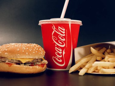 Gomel, Belarus - 5 Şubat 2019: Coca Cola İçecek ve patates kızartması ve karanlık bir arka plan üzerinde burger