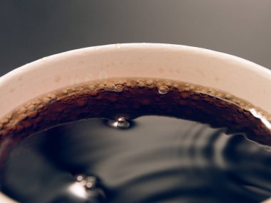 karanlık bir arka plan üzerinde kırmızı kağıt bardak içki