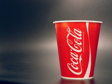 Gomel, Belarus - 5 Şubat 2019: Coca Cola İçecek karanlık bir arka plan üzerinde kırmızı kağıt bardak