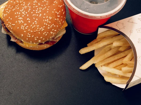 ドリンクとフライド ポテト 暗い背景にハンバーガー — ストック写真