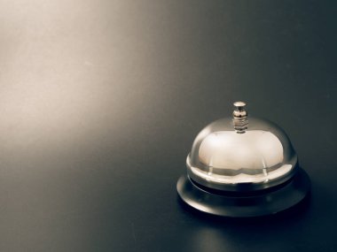 Gümüş bir çan ve siyah bir zemin üzerine Otelin resepsiyonunda anahtar