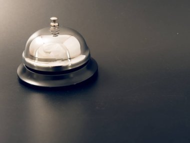 Gümüş bir çan ve siyah bir zemin üzerine Otelin resepsiyonunda anahtar