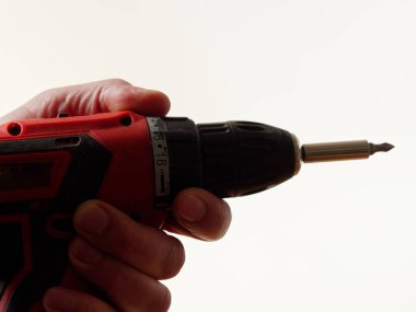 iş giysisi erkekte bir matkap araç beyaz arka plan üzerinde tutar.