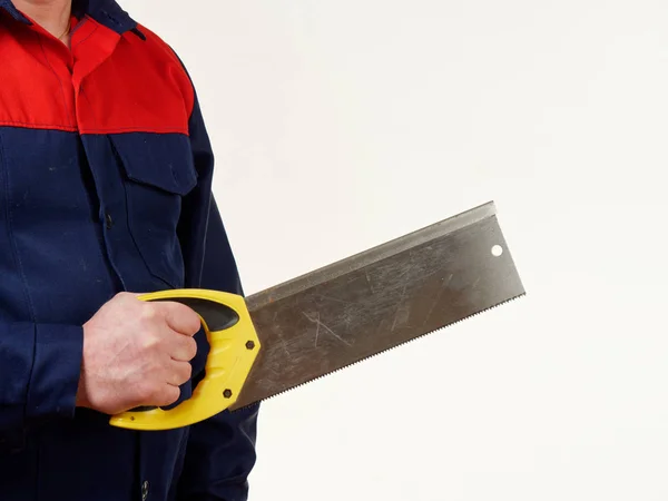 man in workwear is holding a handsaw tool on white background 5