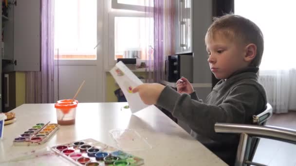 Criança desenha com aquarelas desenho em casa na mesa . — Vídeo de Stock