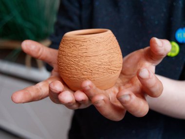 gururla tutan bir kil çömlek çömlekçi çocuk.