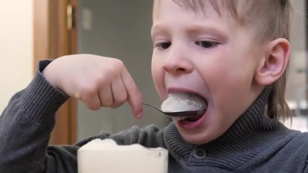 Babyjongen Eten Zuurstof Cocktail Met Een Lepel Uit Een Glas — Stockvideo