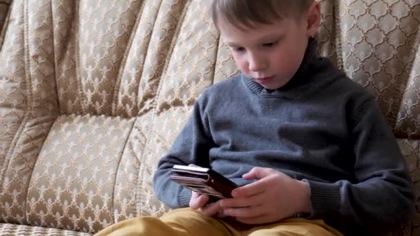 Menino Brincando Telefone Sentado Sofá — Vídeo de Stock
