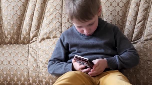 Niño Jugando Teléfono Sentado Sofá — Vídeos de Stock