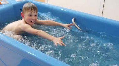 erkek bebek kabarcıkları ile bir duş alıyor. Jakuzi köpük banyosu yordamı.