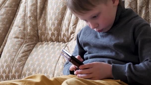 Menino Brincando Telefone Sentado Sofá — Vídeo de Stock