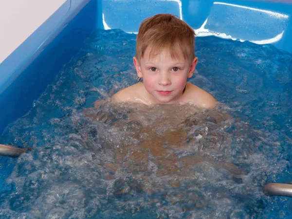 Bébé garçon prend un bain avec des bulles. Procédure de bain bulle jacuzzi . — Photo