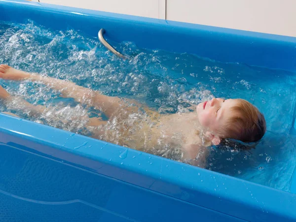 Bébé garçon prend un bain avec des bulles. Procédure de bain bulle jacuzzi . — Photo