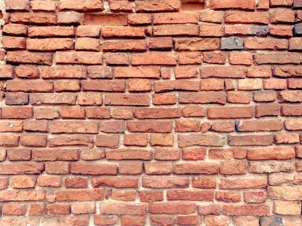 Den gamla muren i rött tegel som förstördes av vind och vatten — Stockfoto