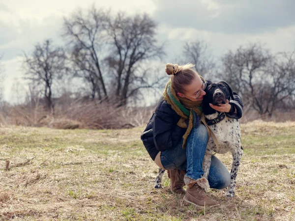 Дівчина гуляє з великим сліпим собакою навесні — стокове фото