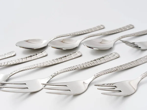 Tenedores de cubiertos y cucharas sobre un fondo blanco — Foto de Stock