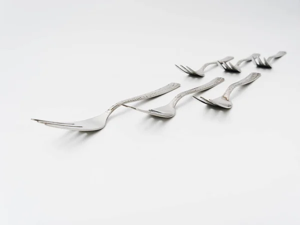 Talheres garfos e colheres em um fundo branco — Fotografia de Stock