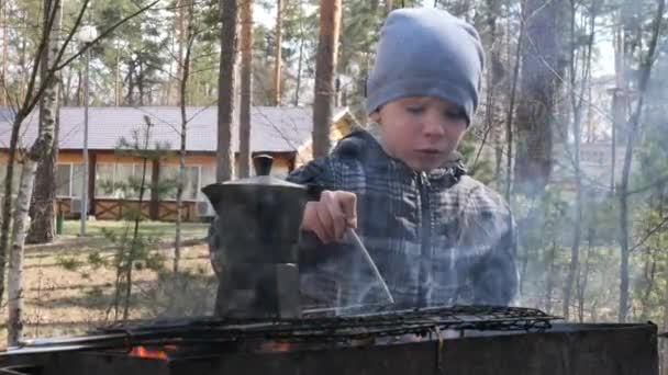 少年はグリルで火の上で食べ物を調理する 国の休息 — ストック動画