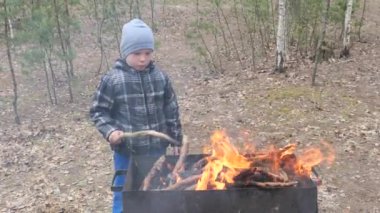 Çocuk ızgarada ateşte yemek pişirir. ülke dinlenme.