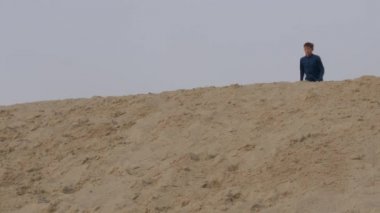 Çocuklar ve gençler beyaz kumda eğlenirler. Parkour