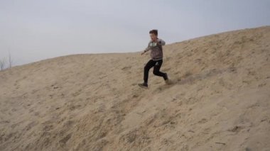 Çocuklar ve gençler beyaz kumda eğlenirler. Parkour