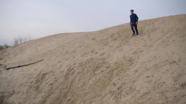 Çocuklar ve gençler beyaz kumda eğlenirler. Parkour