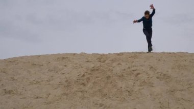 Çocuklar ve gençler beyaz kumda eğlenirler. Parkour