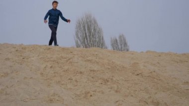 Çocuklar ve gençler beyaz kumda eğlenirler. Parkour