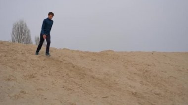 Çocuklar ve gençler beyaz kumda eğlenirler. Parkour